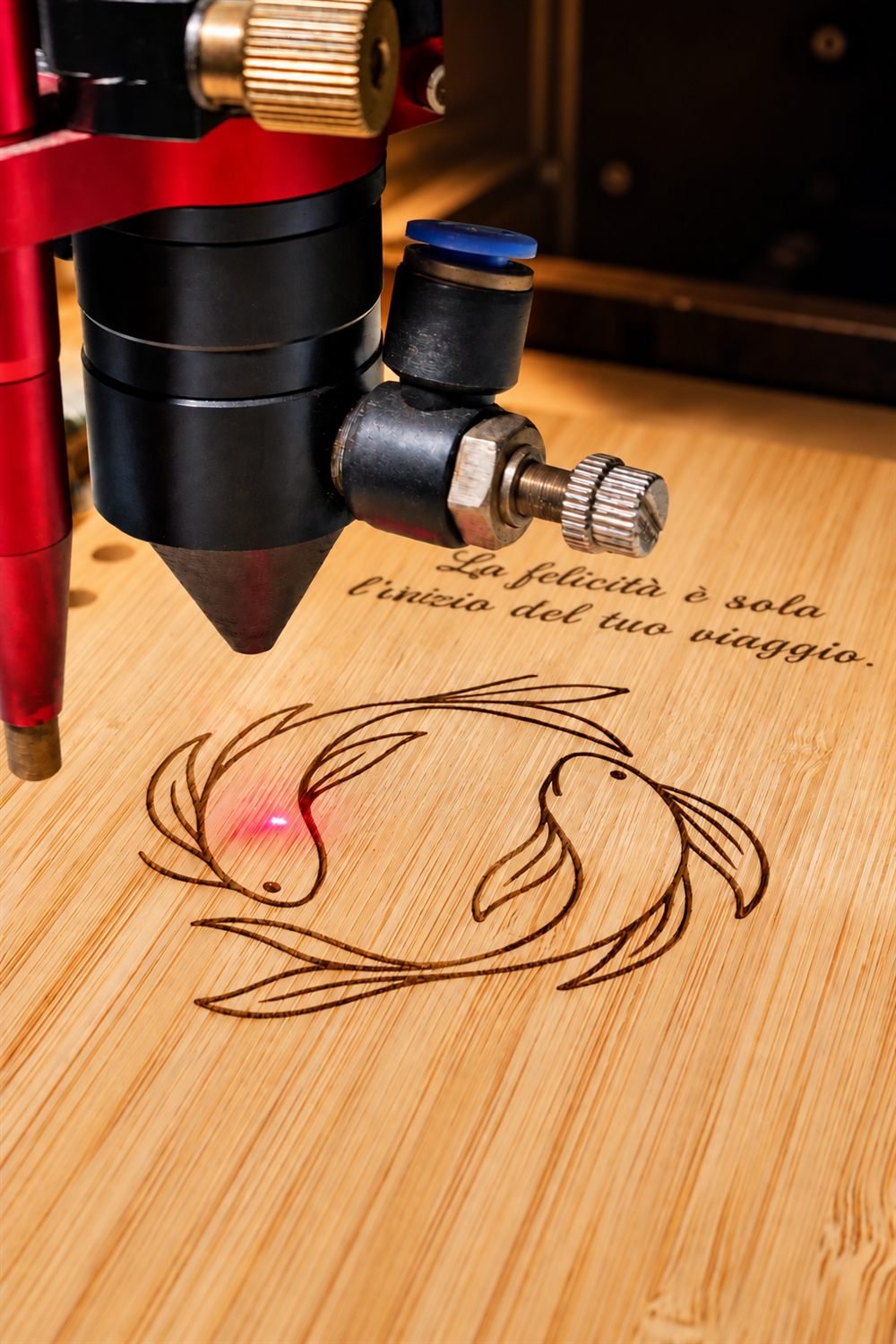 La testa del laser mentre incide un disegno su legno di bambù